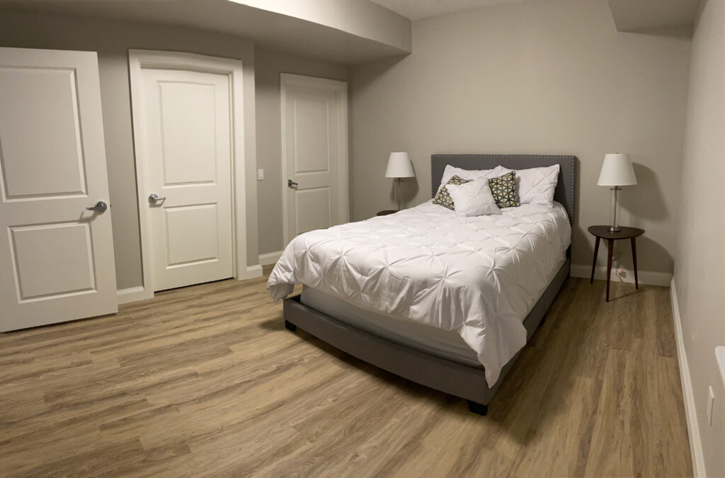 Large bedroom with white bed on light flooring